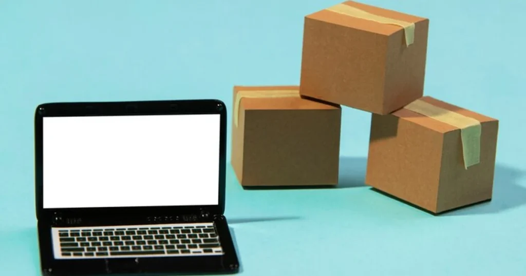 Laptop naast drie gesloten kartonnen dozen